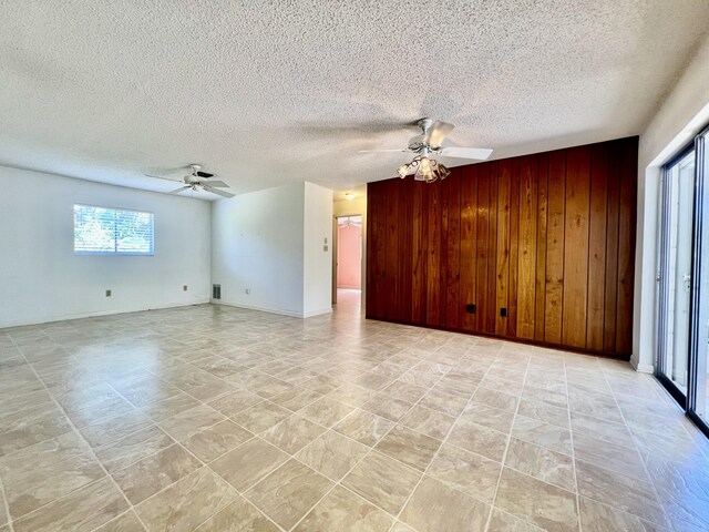 115 15th Ave, Vero Beach, FL 32962 - spare room featuring a ceiling fan, wood walls, and a textured ceiling