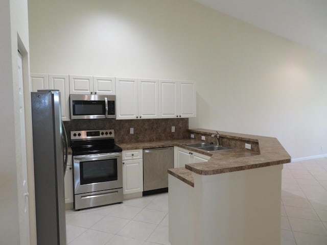 2357 Windjammer Way, West Palm Beach, FL 33411 - kitchen with appliances with stainless steel finishes, a peninsula, dark countertops, white cabinetry, and a high ceiling