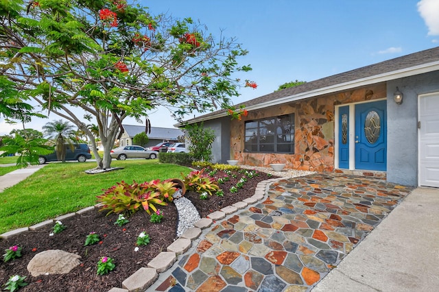 11784 Laurel Valley Cir, Wellington, FL 33414 - view of exterior entry featuring stone siding, a lawn, and stucco siding