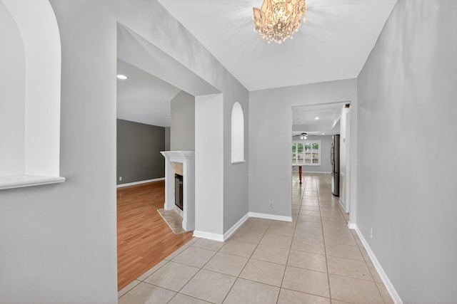 11784 Laurel Valley Cir, Wellington, FL 33414 - hallway featuring arched walkways, a chandelier, light wood-style floors, and recessed lighting