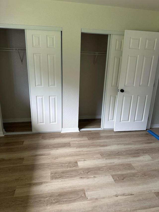 1942 SE Camilo St, Port Saint Lucie, FL 34952 - unfurnished bedroom with two closets and light wood-type flooring