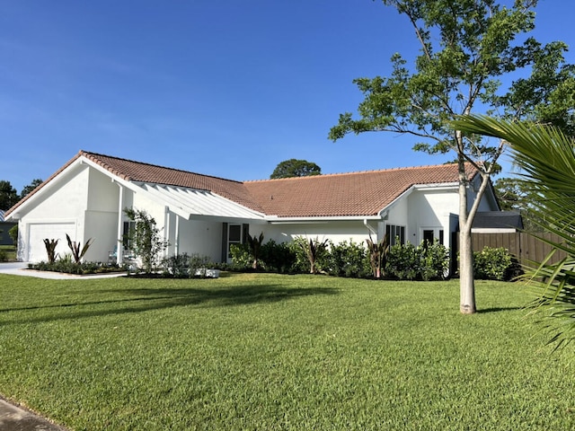 1951 SE Erwin Rd, Port Saint Lucie, FL 34952 - view of front of home featuring a garage, a front lawn, and stucco siding