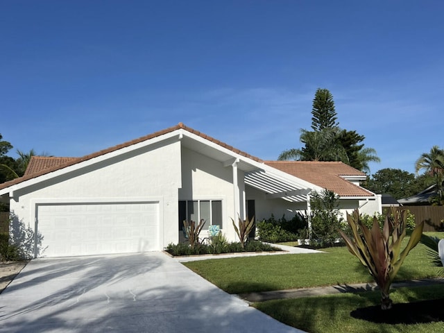 1951 SE Erwin Rd, Port Saint Lucie, FL 34952 - view of front of house featuring a garage, a tiled roof, concrete driveway, and stucco siding