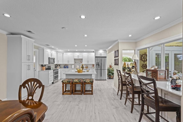 1951 SE Erwin Rd, Port Saint Lucie, FL 34952 - dining area featuring crown molding, a textured ceiling, recessed lighting, and light wood finished floors