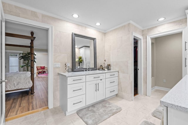 1951 SE Erwin Rd, Port Saint Lucie, FL 34952 - bathroom with ornamental molding, vanity, connected bathroom, a walk in closet, and tile walls