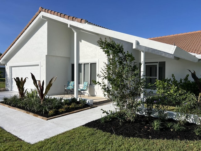 1951 SE Erwin Rd, Port Saint Lucie, FL 34952 - view of property exterior with stucco siding, a tile roof, and a garage
