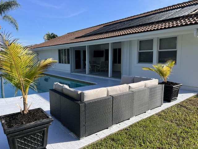 1951 SE Erwin Rd, Port Saint Lucie, FL 34952 - rear view of house featuring outdoor lounge area, solar panels, a patio area, an outdoor pool, and a tile roof