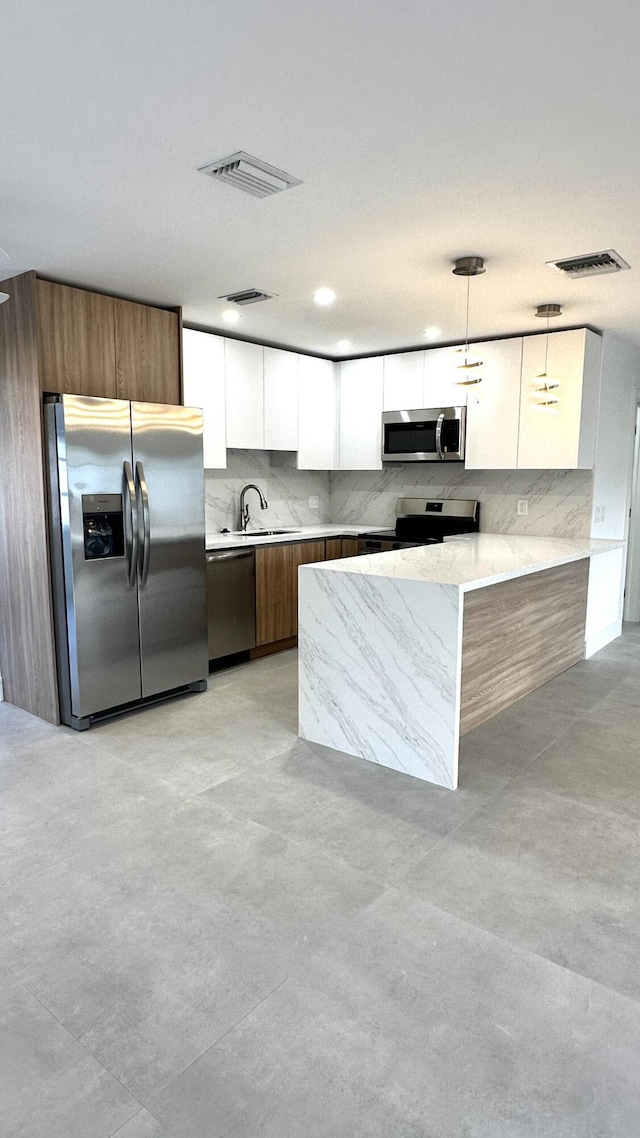 790 Sarazen Dr, West Palm Beach, FL 33413 - kitchen featuring appliances with stainless steel finishes, modern cabinets, white cabinets, hanging light fixtures, and tasteful backsplash