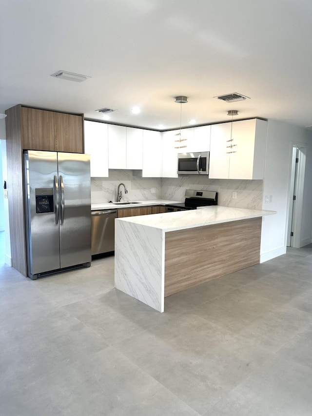 790 Sarazen Dr, West Palm Beach, FL 33413 - kitchen featuring appliances with stainless steel finishes, modern cabinets, white cabinetry, and backsplash