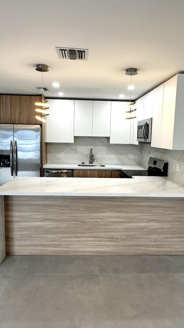790 Sarazen Dr, West Palm Beach, FL 33413 - kitchen with stainless steel appliances, modern cabinets, white cabinetry, and backsplash