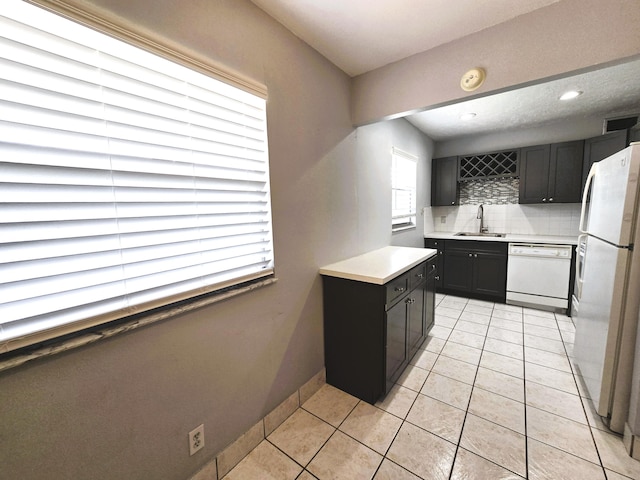89 Saxony B B, Delray Beach, FL 33446 - kitchen with white appliances, backsplash, light tile patterned flooring, light countertops, and dark cabinets