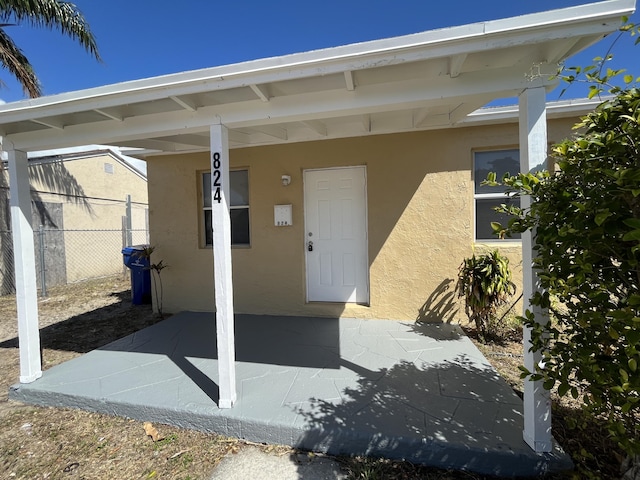 824 W 5th St, Riviera Beach, FL 33404 - doorway to property with stucco siding