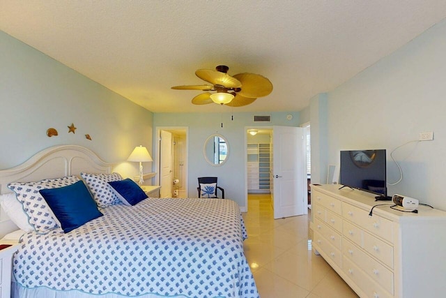 3492 NE Causeway Blvd Unit 104, Jensen Beach, FL 34957 - bedroom featuring light tile patterned floors, a textured ceiling, ceiling fan, and a spacious closet