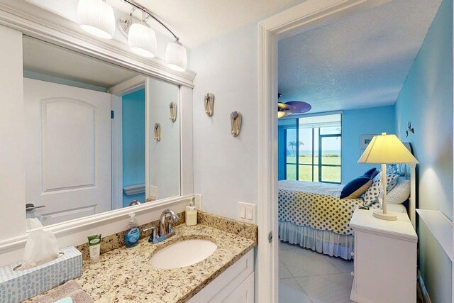 3492 NE Causeway Blvd Unit 104, Jensen Beach, FL 34957 - bathroom with vanity, tile patterned floors, connected bathroom, a ceiling fan, and a textured ceiling