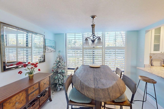 3492 NE Causeway Blvd Unit 104, Jensen Beach, FL 34957 - dining space with light tile patterned flooring, a textured ceiling, and a chandelier