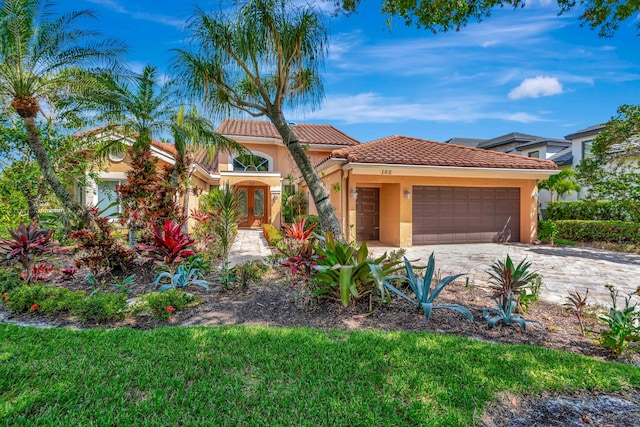 102 Victory Dr, Jupiter, FL 33477 - mediterranean / spanish home with french doors, stucco siding, an attached garage, a tiled roof, and decorative driveway