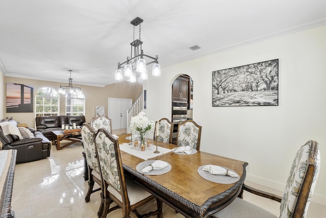 12358 Saint Simon Dr, Boca Raton, FL 33428 - dining room with arched walkways, ornamental molding, a chandelier, and stairs