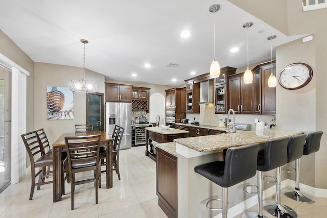12358 Saint Simon Dr, Boca Raton, FL 33428 - kitchen featuring stainless steel appliances, a peninsula, decorative backsplash, a kitchen island, and wall chimney exhaust hood