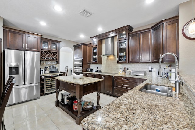 12358 Saint Simon Dr, Boca Raton, FL 33428 - kitchen with appliances with stainless steel finishes, wall chimney range hood, wine cooler, decorative backsplash, and dark brown cabinets