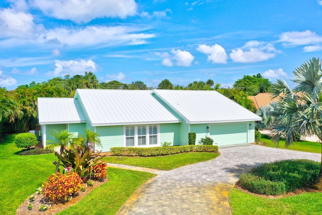 3824 SE Fairway E, Stuart, FL 34997 - single story home with a front yard, a metal roof, decorative driveway, and a garage