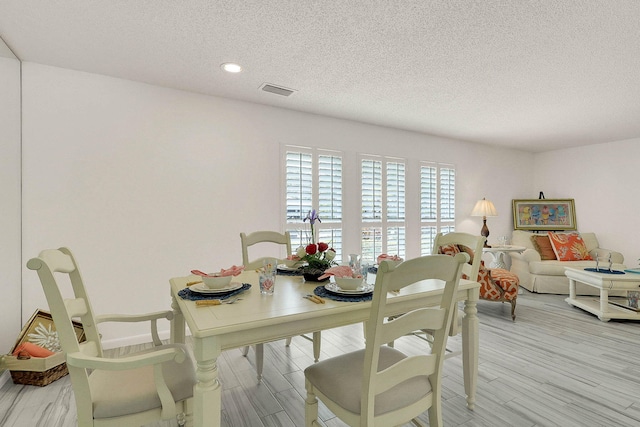 3824 SE Fairway E, Stuart, FL 34997 - dining area featuring a textured ceiling, light wood finished floors, and recessed lighting