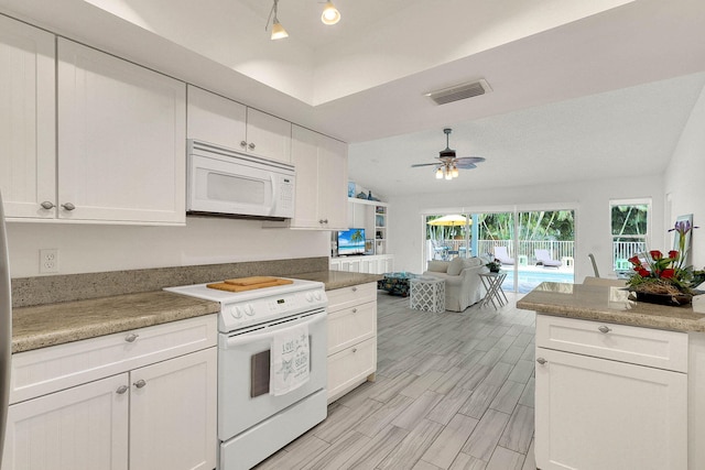 3824 SE Fairway E, Stuart, FL 34997 - kitchen featuring white appliances, white cabinets, open floor plan, ceiling fan, and light wood-style flooring