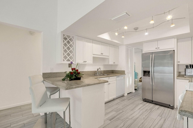 3824 SE Fairway E, Stuart, FL 34997 - kitchen with stainless steel refrigerator with ice dispenser, dishwasher, a tray ceiling, and white cabinetry