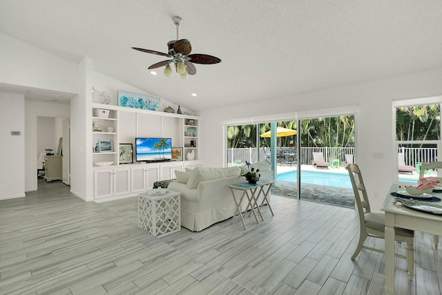 3824 SE Fairway E, Stuart, FL 34997 - living area featuring ceiling fan, lofted ceiling, light wood-type flooring, healthy amount of natural light, and a textured ceiling