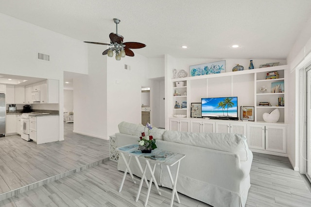 3824 SE Fairway E, Stuart, FL 34997 - living room featuring lofted ceiling, a ceiling fan, recessed lighting, light wood finished floors, and built in features