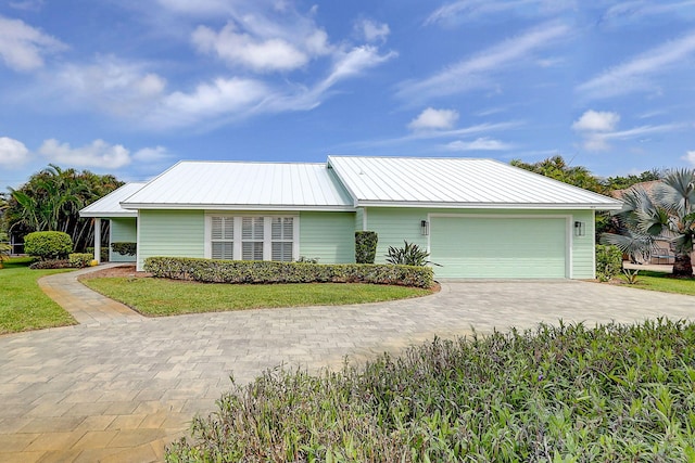 3824 SE Fairway E, Stuart, FL 34997 - view of front of home featuring decorative driveway, an attached garage, and a metal roof