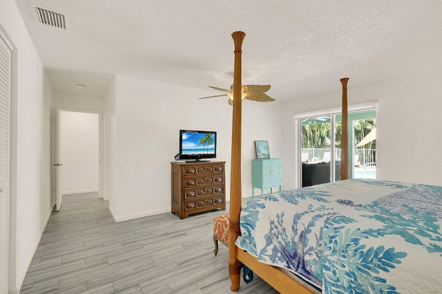 3824 SE Fairway E, Stuart, FL 34997 - bedroom featuring access to outside, a textured ceiling, light wood-style flooring, and a ceiling fan