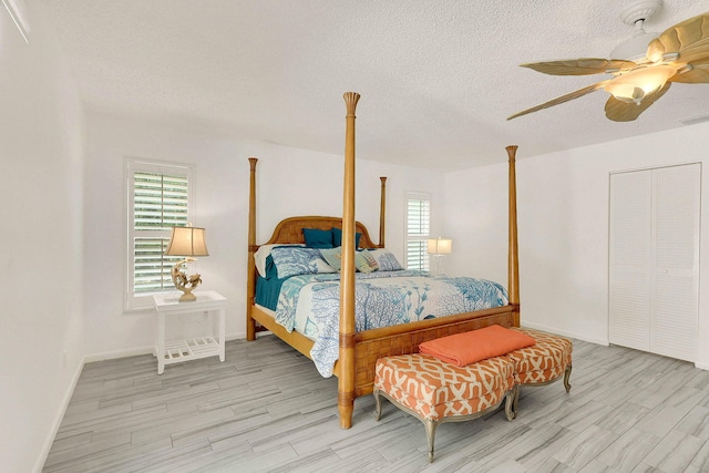 3824 SE Fairway E, Stuart, FL 34997 - bedroom featuring wood finished floors, a textured ceiling, and a ceiling fan