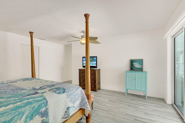 3824 SE Fairway E, Stuart, FL 34997 - bedroom featuring light wood finished floors, a textured ceiling, and a ceiling fan