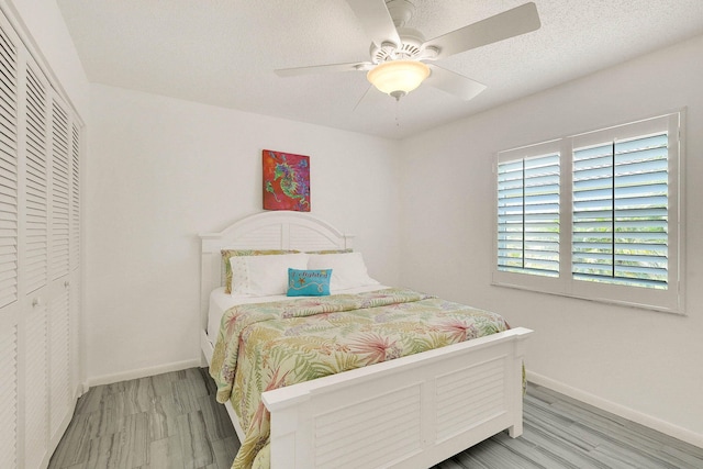 3824 SE Fairway E, Stuart, FL 34997 - bedroom with light wood-style floors, a closet, and ceiling fan