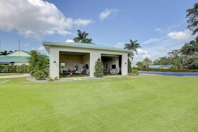 3824 SE Fairway E, Stuart, FL 34997 - rear view of property with stucco siding, a lawn, and a metal roof