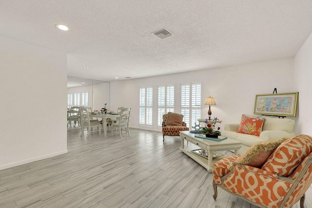 3824 SE Fairway E, Stuart, FL 34997 - living area with light wood-style flooring, a textured ceiling, and recessed lighting