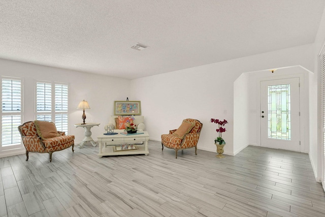 3824 SE Fairway E, Stuart, FL 34997 - living area with plenty of natural light, light wood finished floors, and a textured ceiling
