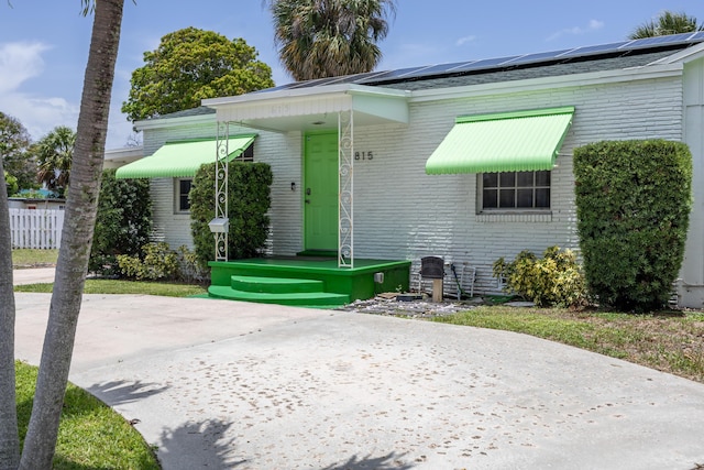 815 Green St, West Palm Beach, FL 33405 - view of front of home with brick siding and roof mounted solar panels