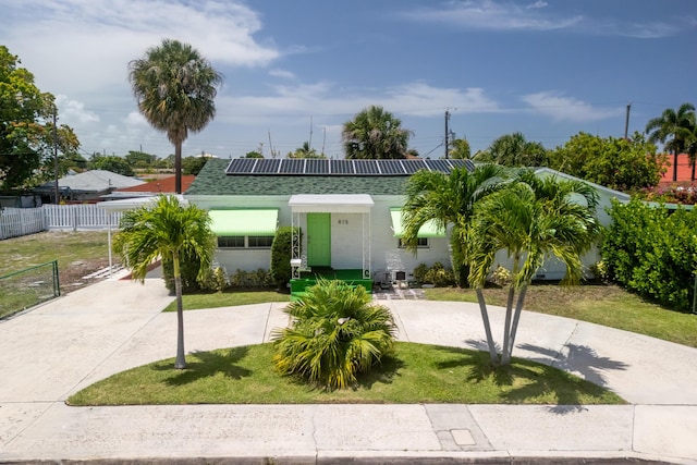 815 Green St, West Palm Beach, FL 33405 - view of front of property with roof mounted solar panels and a shingled roof