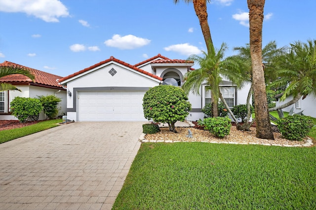 6679 Sherbrook Dr, Boynton Beach, FL 33437 - mediterranean / spanish-style house featuring stucco siding, decorative driveway, a garage, a tiled roof, and a front yard