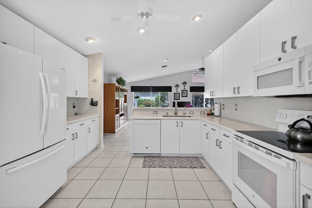 6679 Sherbrook Dr, Boynton Beach, FL 33437 - kitchen with white appliances, vaulted ceiling, backsplash, light countertops, and white cabinets