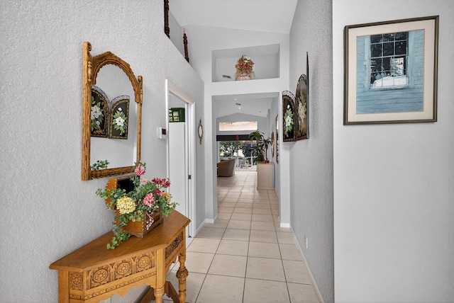 6679 Sherbrook Dr, Boynton Beach, FL 33437 - corridor featuring light tile patterned flooring, vaulted ceiling, and a textured wall