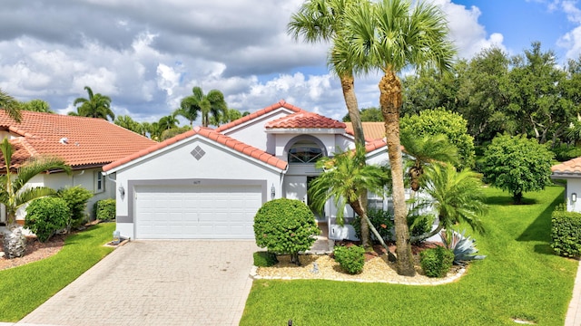 6679 Sherbrook Dr, Boynton Beach, FL 33437 - mediterranean / spanish-style home featuring an attached garage, decorative driveway, a front yard, and stucco siding