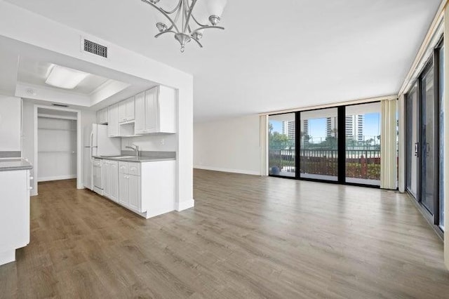 5480 N Ocean Dr Unit B1A, Singer Island, FL 33404 - kitchen featuring wood finished floors, a chandelier, white cabinets, and floor to ceiling windows