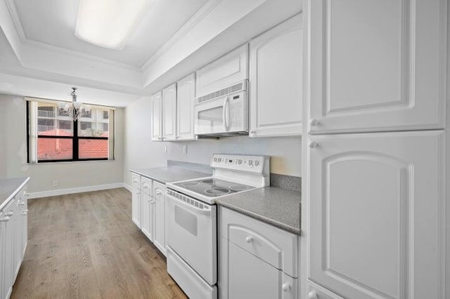 5480 N Ocean Dr Unit B1A, Singer Island, FL 33404 - kitchen featuring white appliances, a tray ceiling, white cabinetry, light wood-type flooring, and a chandelier