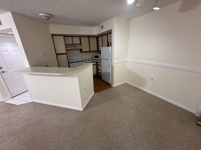 1401 Village Blvd Unit 1914, West Palm Beach, FL 33409 - kitchen with white appliances, carpet, a peninsula, under cabinet range hood, and a textured ceiling