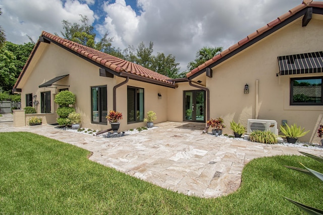 21734 San Simeon Cir, Boca Raton, FL 33433 - back of house featuring a tiled roof, a patio area, stucco siding, french doors, and a lawn