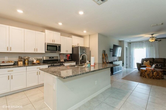 5126 Dandelion St, Apollo Beach, FL 33572 - kitchen featuring appliances with stainless steel finishes, dark stone countertops, light tile patterned flooring, open floor plan, and recessed lighting