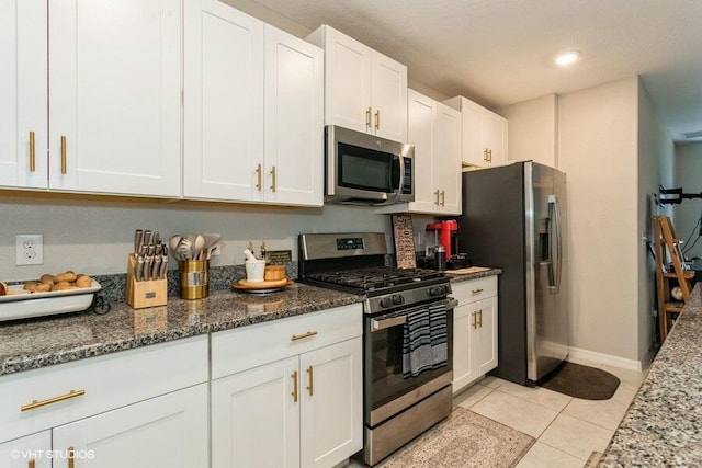 5126 Dandelion St, Apollo Beach, FL 33572 - kitchen featuring stainless steel appliances, white cabinetry, dark stone counters, light tile patterned flooring, and recessed lighting
