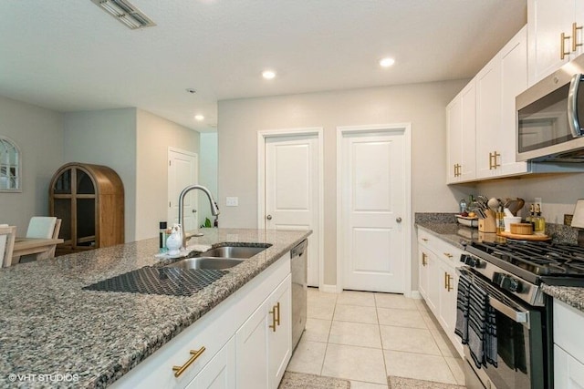 5126 Dandelion St, Apollo Beach, FL 33572 - kitchen featuring stainless steel appliances, dark stone counters, white cabinetry, and recessed lighting